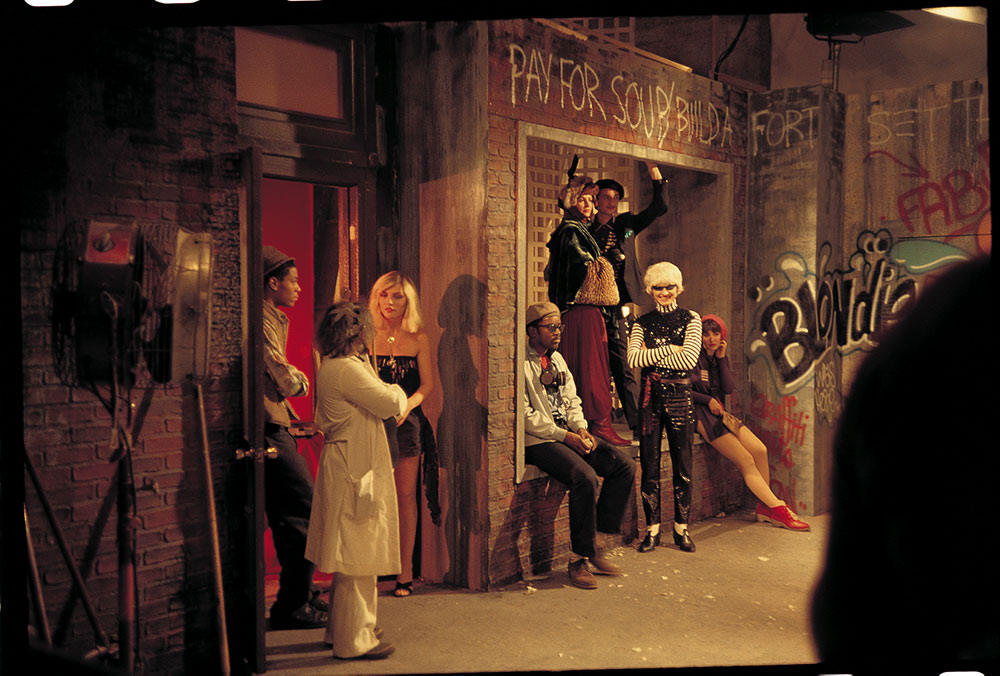 Photography by Charlie Ahearn, [Debbie Harry, Jean-Michel Basquiat, and Fab 5 Freddy with others on the set for the music video for "Rapture"]